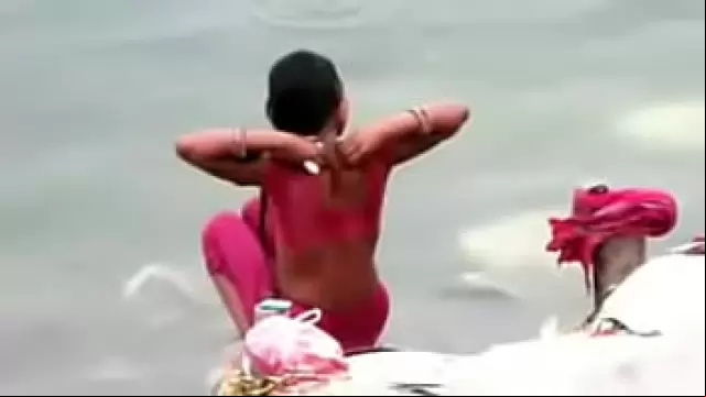 Indian woman bathing in ganges river backless open